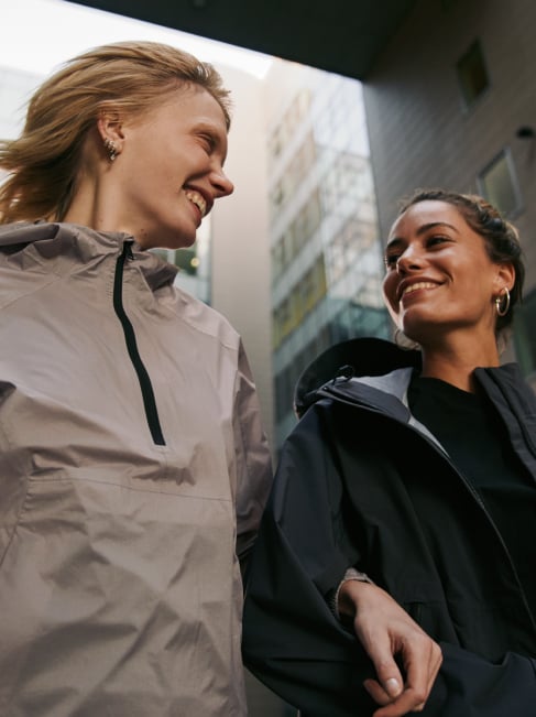 Zwei Frauen spazieren lächelnd durch die Stadt