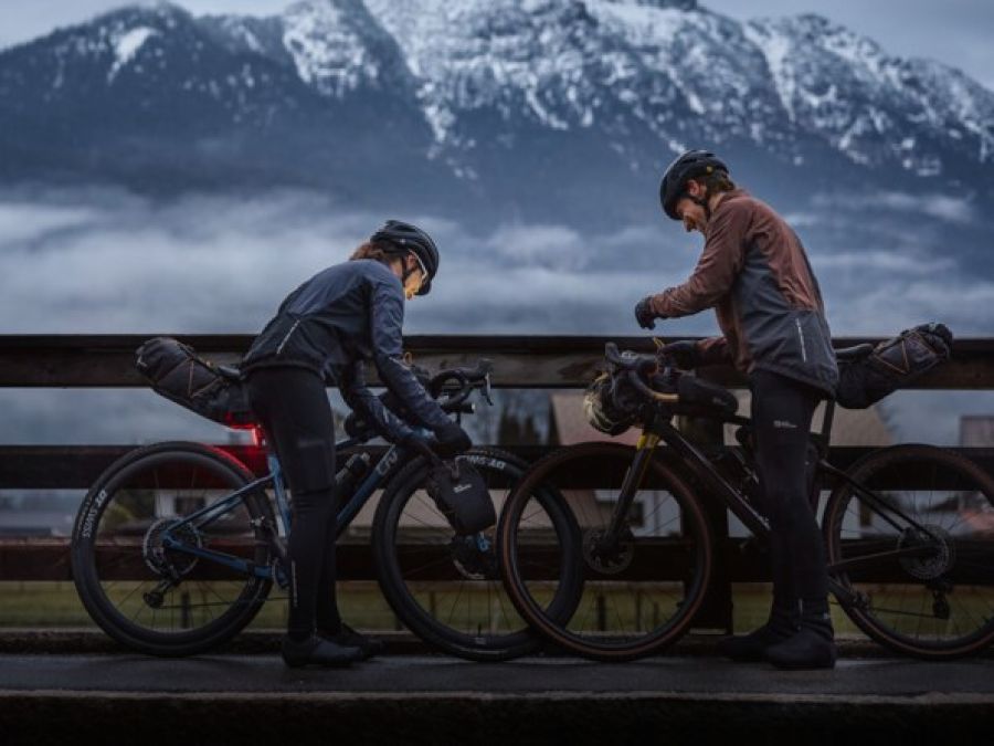 Due ciclisti in un paesaggio montano nebbioso