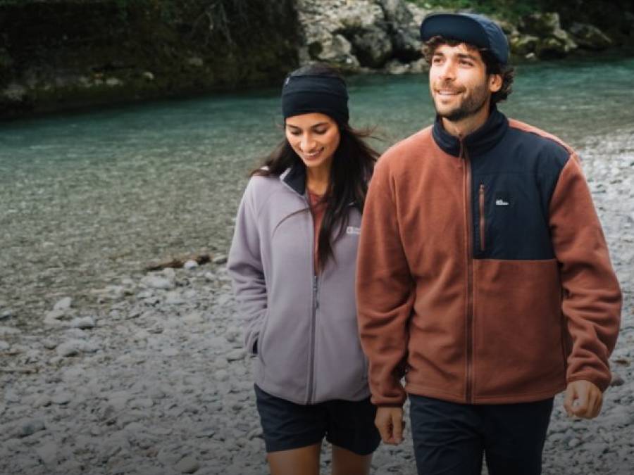 Due giovani adulti con giacche sportive in pile davanti a un lago