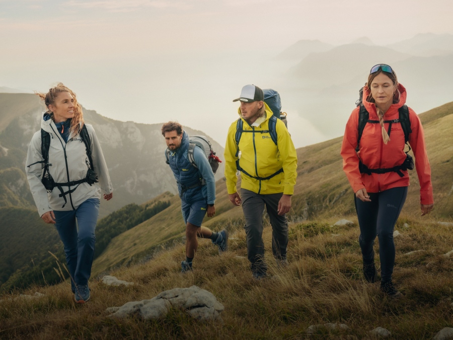 Quattro escursionisti in un paesaggio montano velato