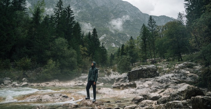 Un uomo in abbigliamento outdoor sta in piedi in un paesaggio montano nebbioso