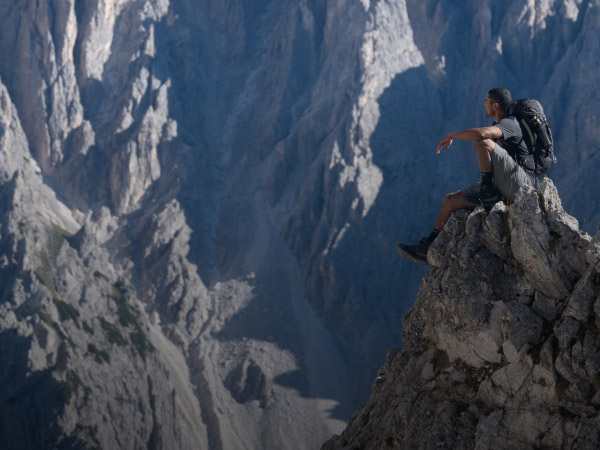 Un escursionista è seduto in cima a una montagna