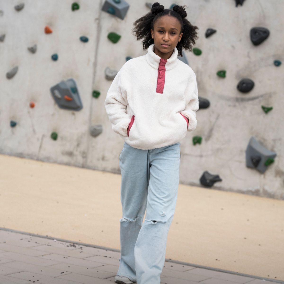 Ragazza davanti alla parete da arrampicata