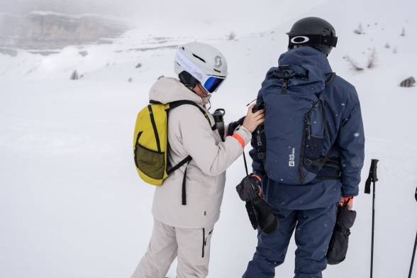 Frau und Mann in Ski-Kleidung in verschneiter Berglandschaft
